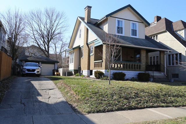 view of front of home with a garage, an outbuilding, covered porch, and a front yard