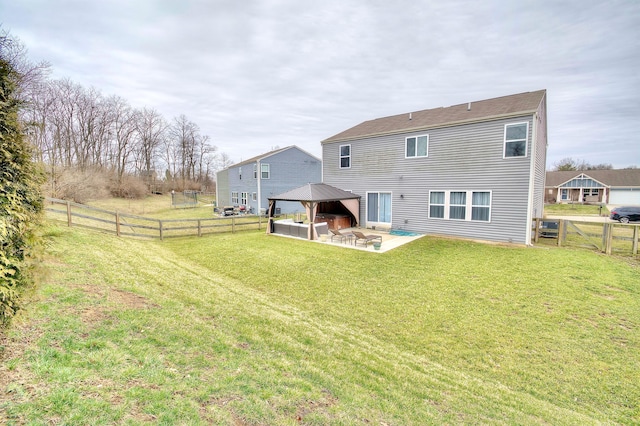 rear view of property featuring a gazebo, a patio, a fenced backyard, and a lawn