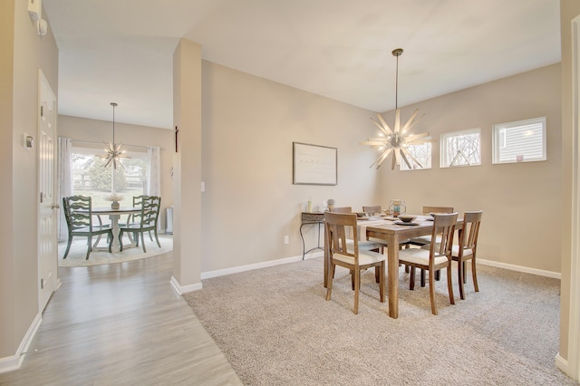 dining room with baseboards, wood finished floors, and an inviting chandelier