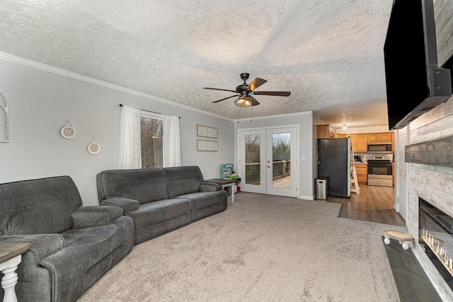 living area featuring a stone fireplace, a textured ceiling, french doors, and ornamental molding