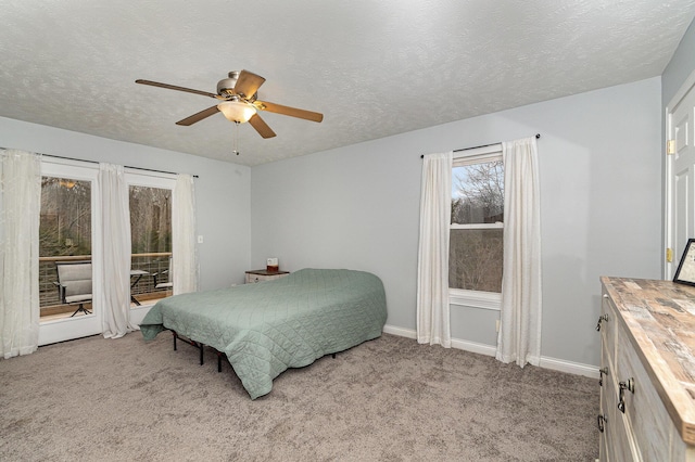 bedroom featuring access to exterior, ceiling fan, baseboards, carpet flooring, and a textured ceiling