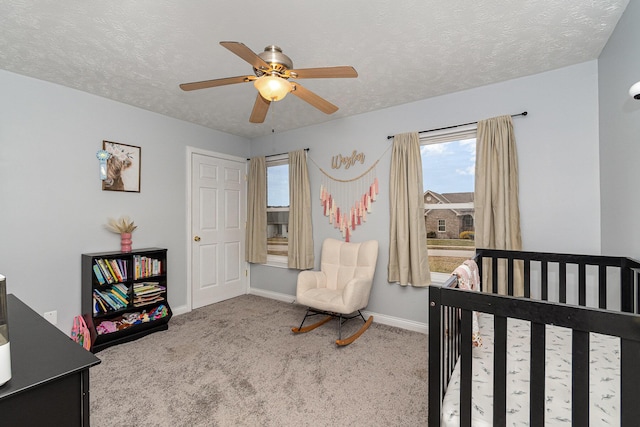 carpeted bedroom featuring a textured ceiling, baseboards, and a ceiling fan