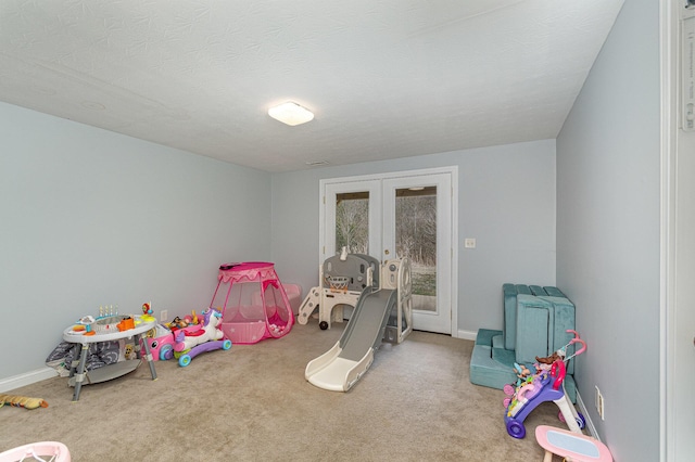 playroom with french doors, a textured ceiling, baseboards, and carpet floors