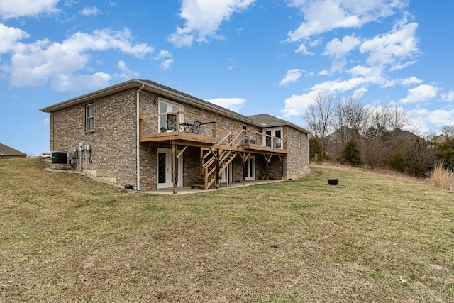 rear view of house featuring a patio, a yard, brick siding, and central AC