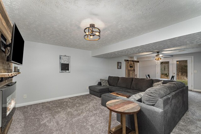 carpeted living area with ceiling fan with notable chandelier, a textured ceiling, and baseboards