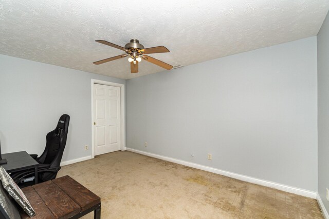 office area with baseboards, light carpet, a textured ceiling, and ceiling fan