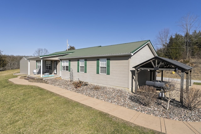 view of front of property featuring metal roof and a front yard