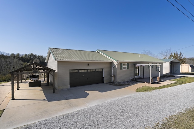 ranch-style home with a storage unit, an attached garage, and metal roof