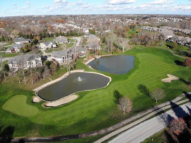 drone / aerial view with view of golf course and a water view