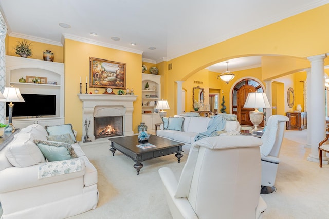 carpeted living room with ornamental molding, built in features, a warm lit fireplace, arched walkways, and decorative columns