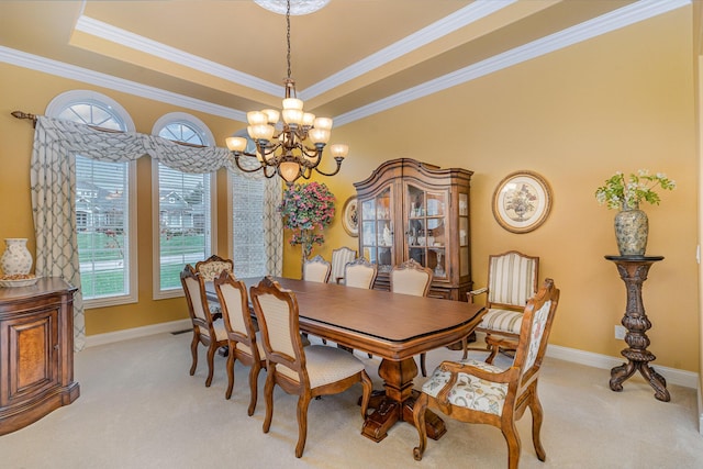 dining space featuring baseboards, a raised ceiling, light colored carpet, and ornamental molding