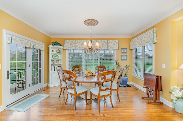 dining area with light wood finished floors, baseboards, an inviting chandelier, and ornamental molding