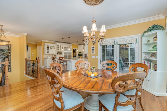 dining room with light wood finished floors, a notable chandelier, and ornamental molding