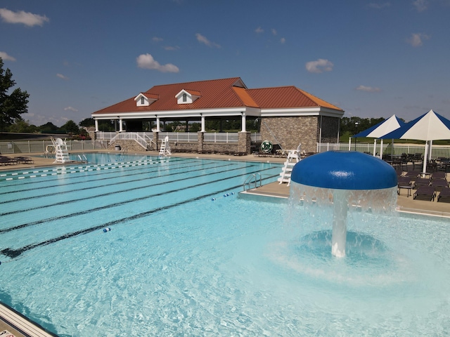 community pool featuring a patio and fence