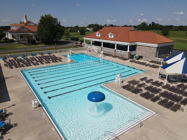 pool with a patio area and fence