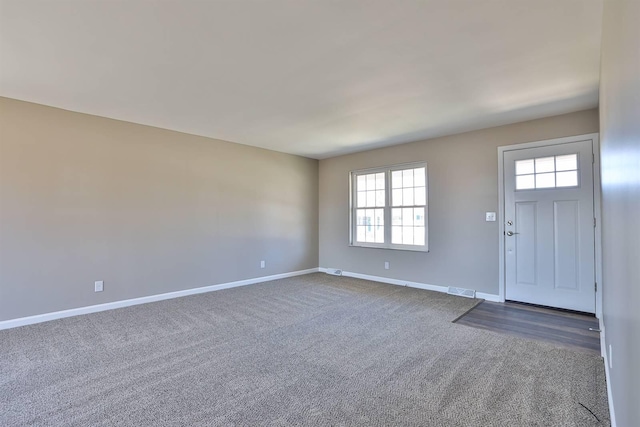 carpeted foyer entrance with visible vents and baseboards