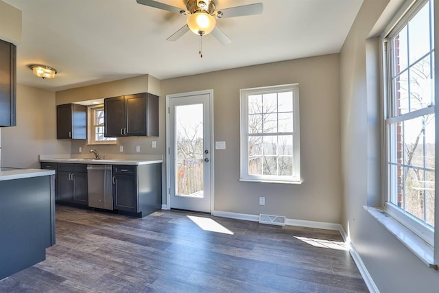 kitchen featuring visible vents, dishwasher, dark wood-style floors, and light countertops