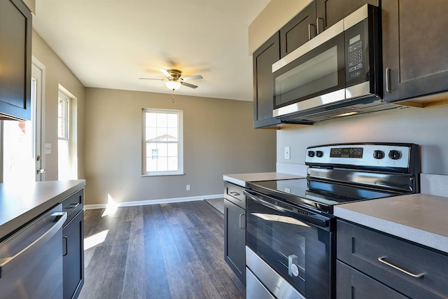 kitchen featuring baseboards, dark wood finished floors, ceiling fan, light countertops, and appliances with stainless steel finishes