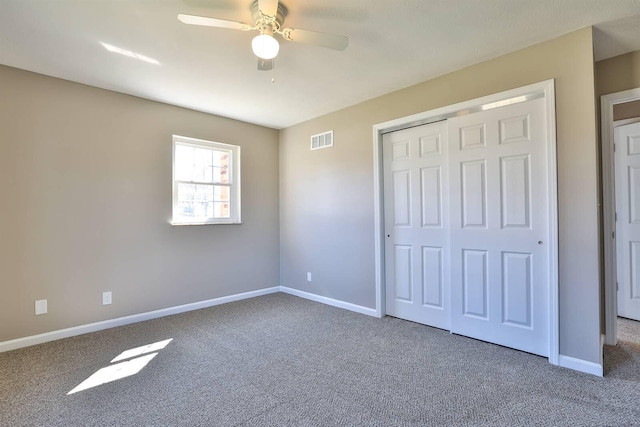 unfurnished bedroom featuring visible vents, baseboards, carpet flooring, a closet, and a ceiling fan