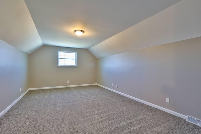 additional living space with lofted ceiling, carpet flooring, baseboards, and visible vents