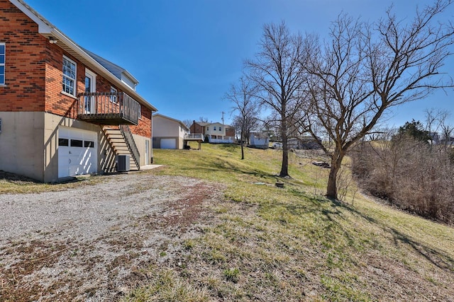 view of yard with stairway, cooling unit, driveway, and an attached garage