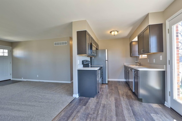 kitchen with light countertops, baseboards, visible vents, and a sink