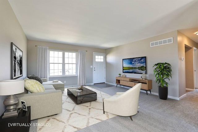 carpeted living room with visible vents and baseboards