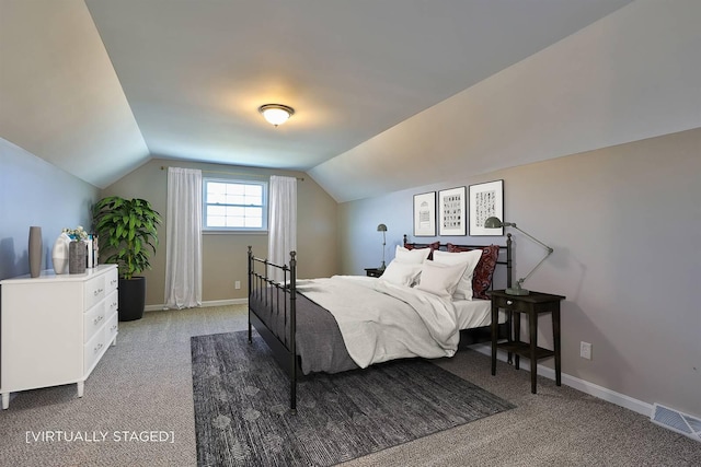 bedroom with vaulted ceiling, light colored carpet, and visible vents