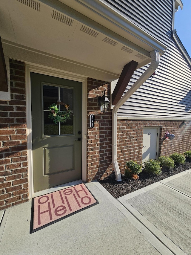 entrance to property featuring brick siding