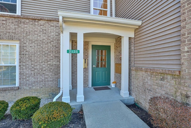 entrance to property featuring brick siding