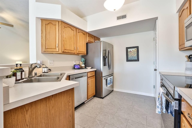 kitchen featuring baseboards, visible vents, a sink, light countertops, and appliances with stainless steel finishes