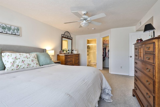 bedroom with visible vents, a ceiling fan, a textured ceiling, light colored carpet, and a spacious closet