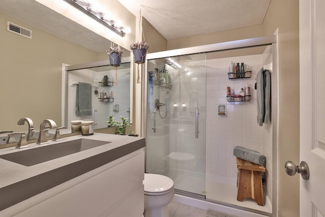 bathroom featuring visible vents, toilet, a shower stall, and a textured ceiling