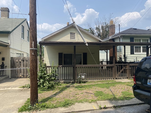 bungalow-style home with a porch and fence