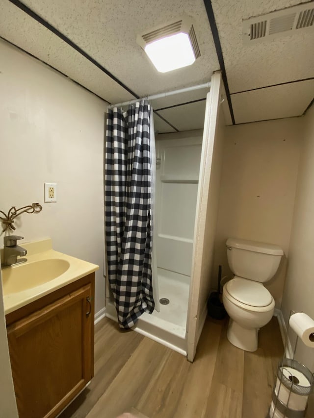 full bathroom with vanity, wood finished floors, visible vents, a stall shower, and toilet