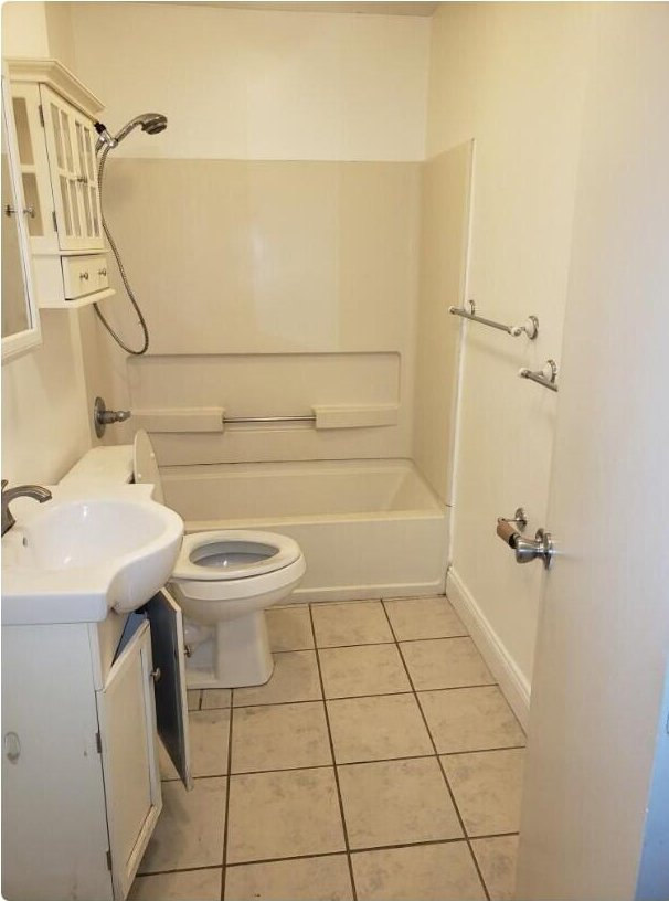 bathroom featuring toilet, shower / washtub combination, vanity, and tile patterned flooring