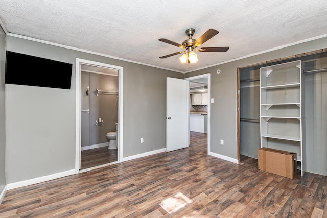 unfurnished bedroom with ornamental molding, a textured ceiling, baseboards, and wood finished floors