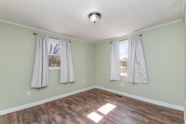 unfurnished room featuring wood finished floors, visible vents, and baseboards