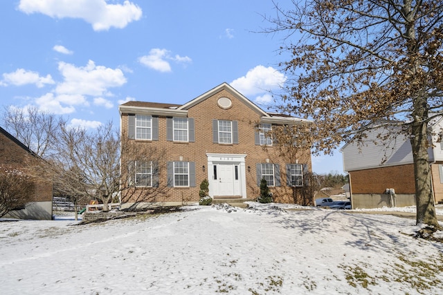 colonial home featuring brick siding