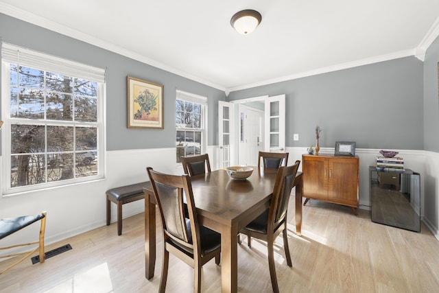 dining area featuring visible vents, plenty of natural light, light wood-style floors, and ornamental molding