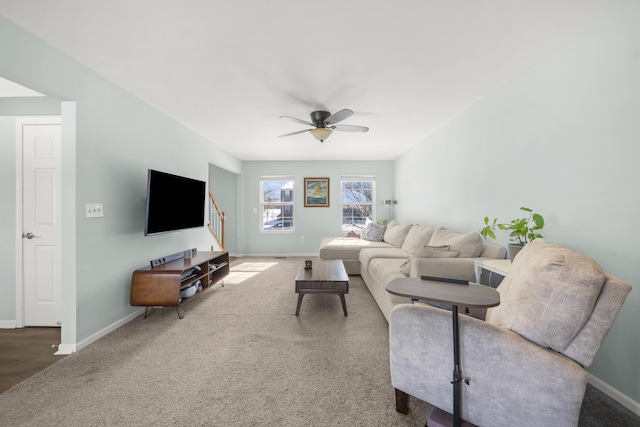 living area featuring carpet, baseboards, and ceiling fan