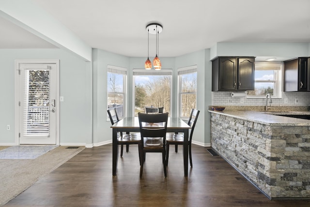 dining room with dark wood finished floors, visible vents, and baseboards