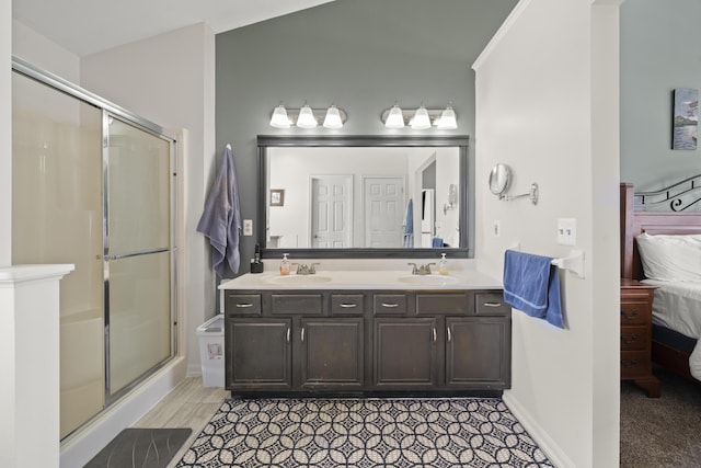 ensuite bathroom with connected bathroom, a shower stall, and a sink