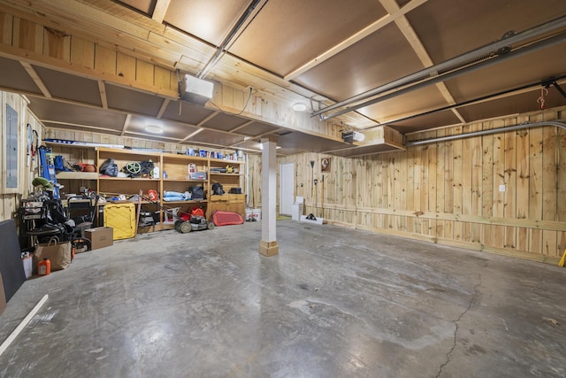 garage with wooden walls and a garage door opener