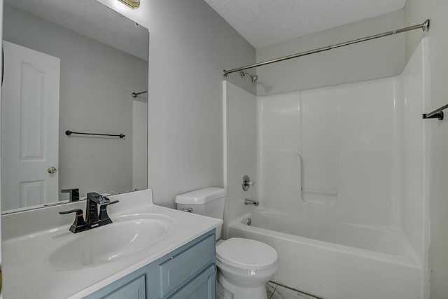 bathroom featuring toilet, shower / washtub combination, vanity, and a textured ceiling