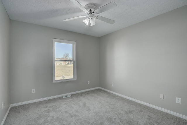 carpeted empty room featuring visible vents, baseboards, a textured ceiling, and ceiling fan