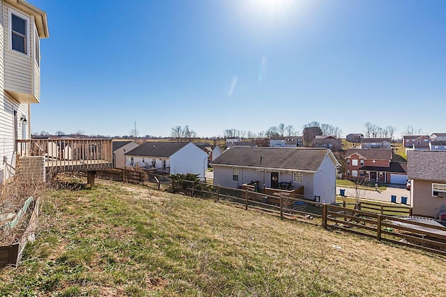 view of yard featuring a wooden deck, a residential view, and fence