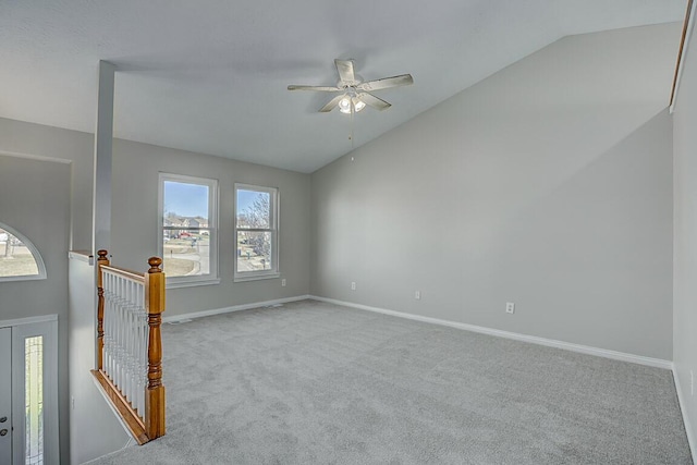 spare room with carpet flooring, a healthy amount of sunlight, baseboards, and lofted ceiling