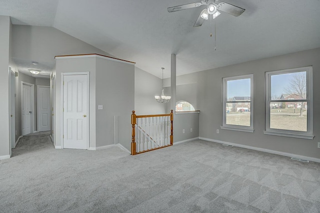 carpeted empty room featuring visible vents, lofted ceiling, and baseboards