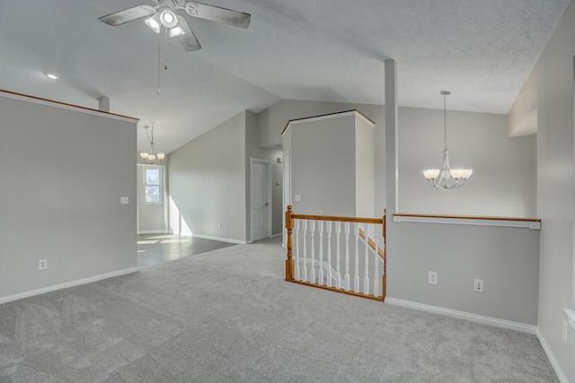 unfurnished room featuring baseboards, lofted ceiling, carpet floors, ceiling fan with notable chandelier, and a textured ceiling